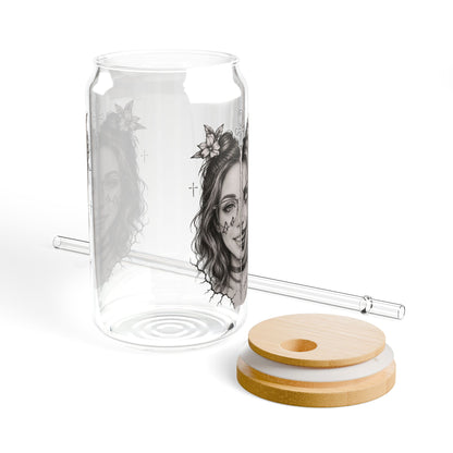 Clear glass tumbler with a design, wooden lid, and straw on a white background